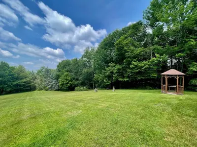 a gazebo in the middle of a grass field at Fire Pit, BBQ & Sprawling Lawn Elk Point Cabin in Livingston Manor