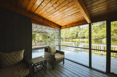 a screened in porch with a couch and a table at Lake House, Fire Pit, Games Magnolia Lake House in Ferndale
