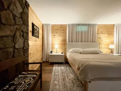 a bedroom with a bed and a stone wall at Red Tail Ridge in North Branch