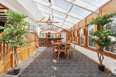 a conservatory with a dining room with a table and chairs at The birch House Heated Pool, Sauna, Hot Tub & More in Dover