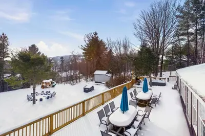 a patio with tables and chairs in the snow at The birch House Heated Pool, Sauna, Hot Tub & More in Dover