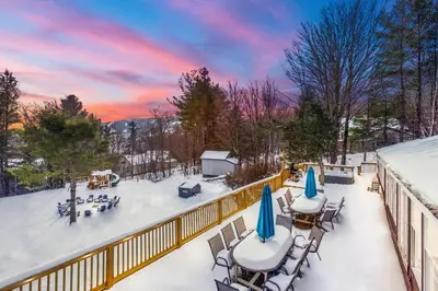 a balcony with tables and chairs in the snow at The birch House Heated Pool, Sauna, Hot Tub & More in Dover