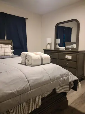 a bedroom with a bed with a dresser and a mirror at 3 bedrooms fully finished in Middletown