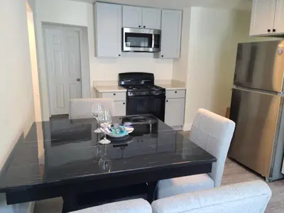 a kitchen with a black table with chairs and a refrigerator at 3 bedrooms fully finished in Middletown