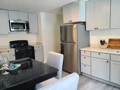 a kitchen with white cabinets and a stainless steel refrigerator at 3 bedrooms fully finished in Middletown
