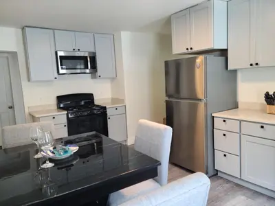 a kitchen with a black table and a stainless steel refrigerator at 3 bedrooms fully finished in Middletown
