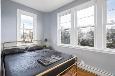 a bedroom with a bed in a room with windows at One BR near Metlife with Laundry & Parking in Lodi