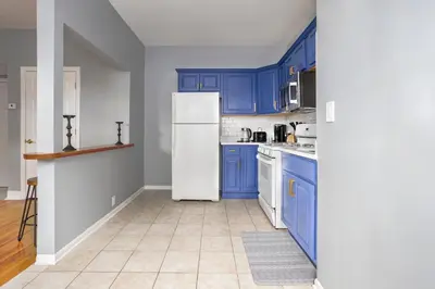 a kitchen with blue cabinets and a white refrigerator at One BR near Metlife with Laundry & Parking in Lodi