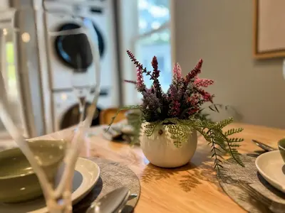 a table with a vase of flowers on top of it at Serenity Haven - A Modern Retreat in Monroe