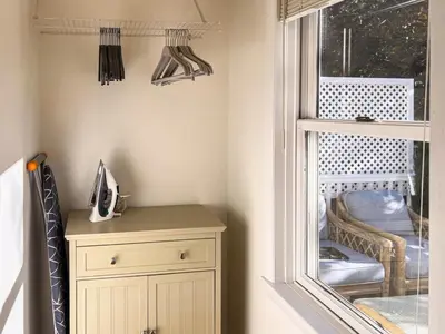 a room with a cabinet and a window with a chair at Serenity Haven - A Modern Retreat in Monroe