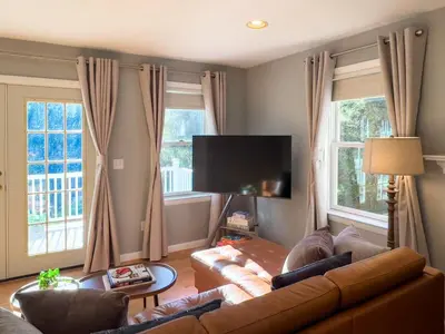 a living room with a couch and a flat screen tv at Serenity Haven - A Modern Retreat in Monroe