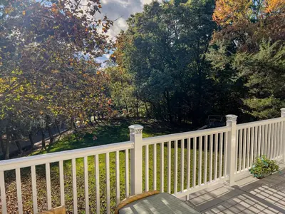a white fence with a chair on a porch at Serenity Haven - A Modern Retreat in Monroe