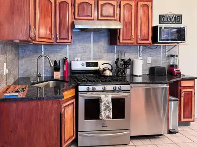 a kitchen with a stainless steel stove and wooden cabinets at New York Skyline One of a Kind View in Union City