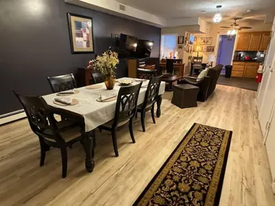 a dining room and living room with a table and chairs at NY-NJ Tennis Suites - Sleeps 40 - 15 Mins to NYC in Union City