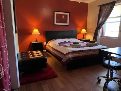 a bedroom with a bed and a chair and a table at NY-NJ Tennis Suites - Sleeps 40 - 15 Mins to NYC in Union City