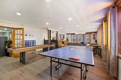 a ping pong table in the middle of a room at Myrtle Villa 7BR Near Mount Snow with Indoor Heated Endless Style Pool Outdoor Hot Tub in Dover