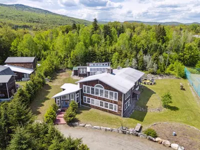 an aerial view of a large house on a river at Myrtle Villa 7BR Near Mount Snow with Indoor Heated Endless Style Pool Outdoor Hot Tub in Dover