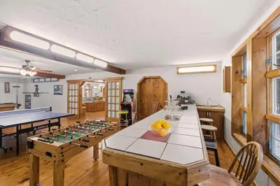 a kitchen with a table and a ping pong game at 12BR Villa Near Mount Snow Sleeps 32 Hot Tub & Indoor Pool in Dover