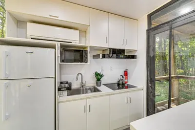 a white kitchen with a sink and a refrigerator at Waterfront Durham Getaway with Deck and Trails! in East Durham