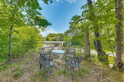 a picnic table and chairs in the woods at Waterfront Durham Getaway with Deck and Trails! in East Durham