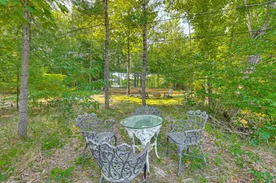 a glass table and four chairs in a park at Waterfront Durham Getaway with Deck and Trails! in East Durham