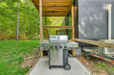a stove sitting in front of a house at Waterfront Durham Getaway with Deck and Trails! in East Durham