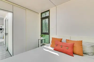 a bedroom with a white bed with orange pillows at Waterfront Durham Getaway with Deck and Trails! in East Durham