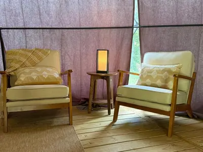 two chairs and a table with a lamp in a room at Boutique Glamping Dome in the Catskill Mountains in Gilboa
