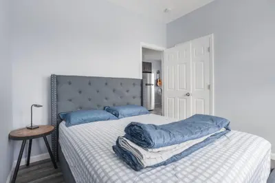a bedroom with a bed with blue pillows on it at Two BR near Metlife with Laundry & Parking in Lodi