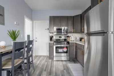 a kitchen with stainless steel appliances and wooden cabinets at Two BR near Metlife with Laundry & Parking in Lodi