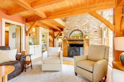 a living room with a fireplace and wooden ceilings at 10 Mi to Mt Snow! Grand Estate Built to Entertain in Wilmington