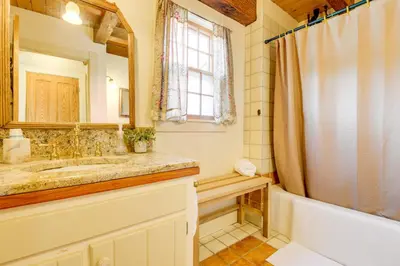 a bathroom with a tub and a sink and a mirror at 10 Mi to Mt Snow! Grand Estate Built to Entertain in Wilmington