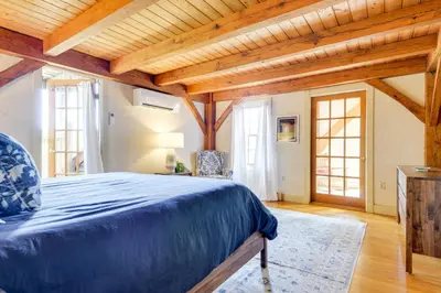 a bedroom with a blue bed in a room with wooden ceilings at 10 Mi to Mt Snow! Grand Estate Built to Entertain in Wilmington