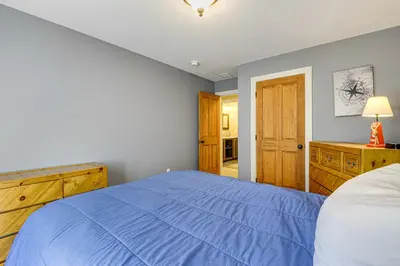 a bedroom with a blue bed and a wooden cabinet at 6 Mi to Mt Snow Grand Summit Resort Spacious Home in Wilmington