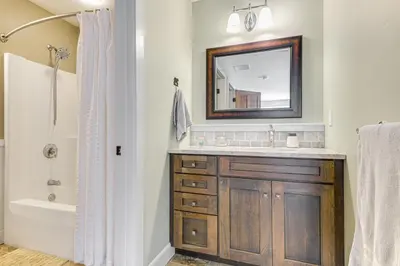 a bathroom with a sink and a tub and a mirror at 6 Mi to Mt Snow Grand Summit Resort Spacious Home in Wilmington