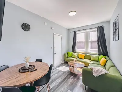 a living room with a green couch and a table at Three BR near Metlife with Laundry & Parking in Lodi