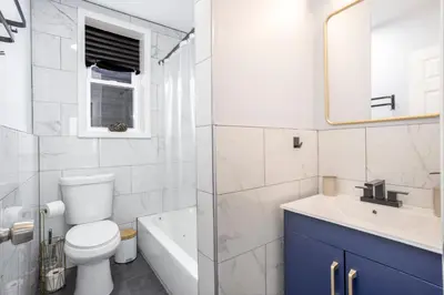 a bathroom with a toilet and a sink and a tub at Three BR near Metlife with Laundry & Parking in Lodi