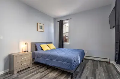 a bedroom with a blue bed and a window at Three BR near Metlife with Laundry & Parking in Lodi