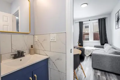 a kitchen and living room with a sink and a couch at Three BR near Metlife with Laundry & Parking in Lodi