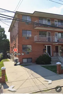 a brick building with a balcony on the side of it at NYC Bayside LIRR Cozy Suite in Bayside