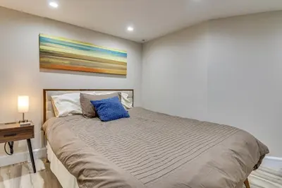 a bedroom with a bed with a blue pillow on it at Walk to Hudson River Parks Recently Renovated Apt in Hoboken