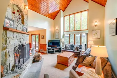a living room with a large stone fireplace at Game Room, Hot Tub! Year-Round Dover Retreat in West Dover