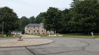 a street with a house and a round driveway at 2 bedrooms with movie theater in Agawam