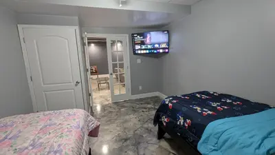 a bedroom with a bed and a tv on the wall at 2 bedrooms with movie theater in Agawam