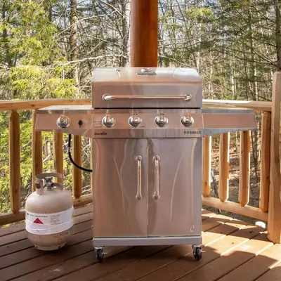 a grill sitting on a deck on a porch at Luxury Log Cabin Lakefront, Game room & Fire Pit, in Schenevus
