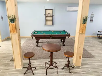 a room with a pool table and two stools at Luxury Log Cabin Lakefront, Game room & Fire Pit, in Schenevus