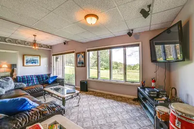 a living room with a couch and a tv at Pet-Friendly Catskills Home with Serene Pond! in Jefferson