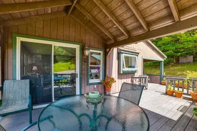 a patio with a table and chairs on a porch at Pet-Friendly Catskills Home with Serene Pond! in Jefferson