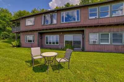 a table and chairs in front of a house at Pet-Friendly Catskills Home with Serene Pond! in Jefferson
