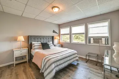 a bedroom with a bed and two windows at Pet-Friendly Catskills Home with Serene Pond! in Jefferson